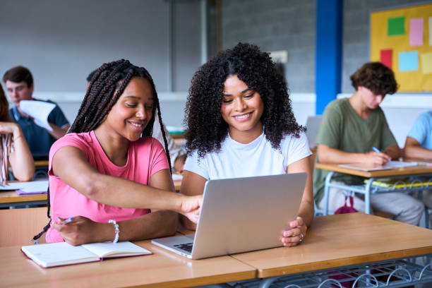 istock Students are studying with computer laptop in library. Young people are spending time together 2197248224