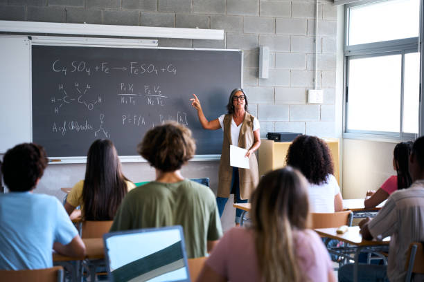 istock View from behind a group of multiracial students taking notes in a classroom 2197248517
