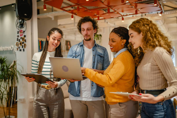 istock diverse group businesspeople stand and use laptop in the office 2197248709