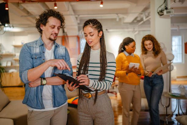 istock two colleagues read together information from clipboard at office 2197248854