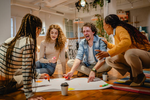 istock multicultural colleagues gather around a large paper on a wooden floor 2197249851