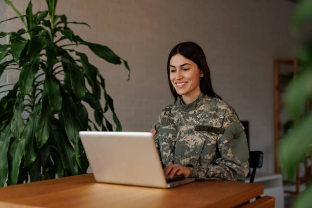 istock Smiling US Army soldier using laptop at home 2197254112