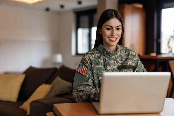 istock Smiling US Army soldier working on laptop at home 2197254156