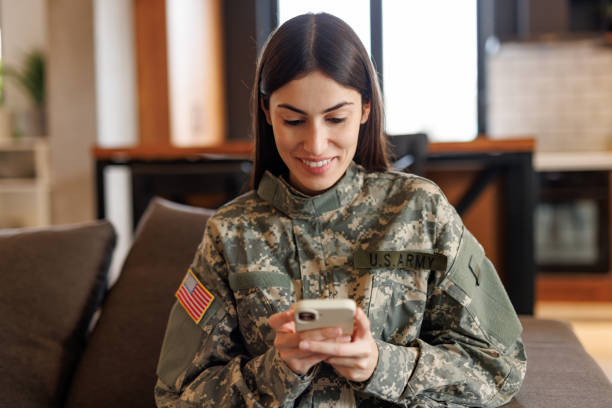 istock Smiling U.S. Army soldier using smartphone at home 2197254190