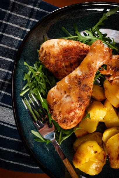 istock Baked chicken drumsticks with potatoes. 2197254362