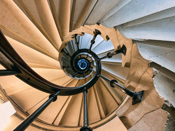 Paris, France - January 27, 2025. View of a spiral staircase from the basement of the Palais de Justice in Paris. The medieval stone staircase is visible in the foreground and the wooden frame is visible in the eye of the staircase. The staircase is located in the part accessible to the public entering the courthouse.
