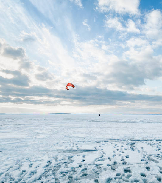 istock Man kiteboarding on huge frozen lake covered with thick snow. 2197261438