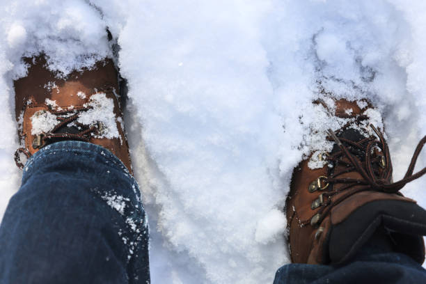 The boots are in the snow. Snow lies on the boots. The concept of snowy weather and winter walks.