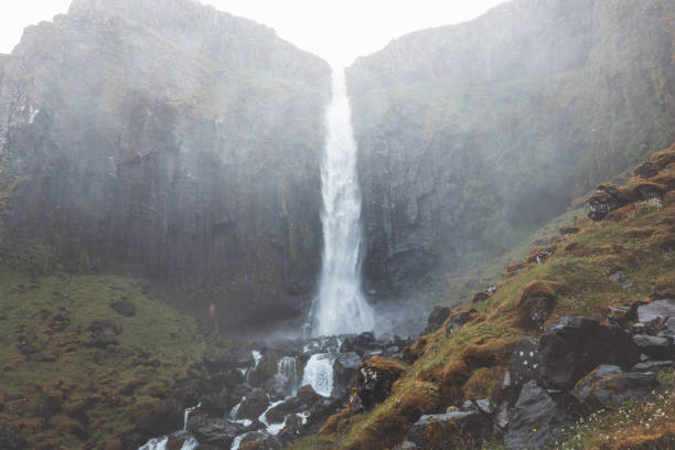 istock Grundarfoss waterfall on the Snaefellsnes Peninsula, Iceland, cascading from dramatic basalt cliffs into a rugged stream below, surrounded by mossy slopes and rocky terrain 2197263520