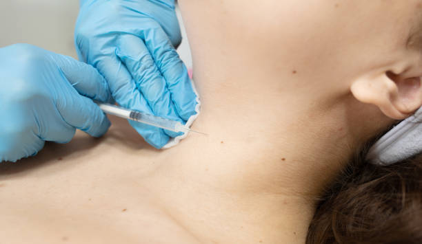 istock woman is getting injection  in her neck. 2197265315