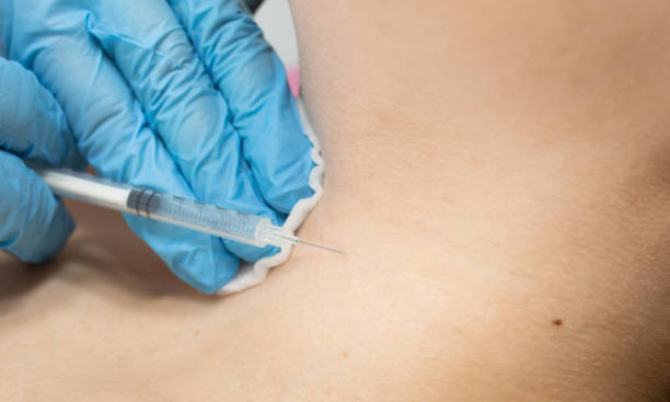 istock woman is getting injection  in her neck. 2197265322