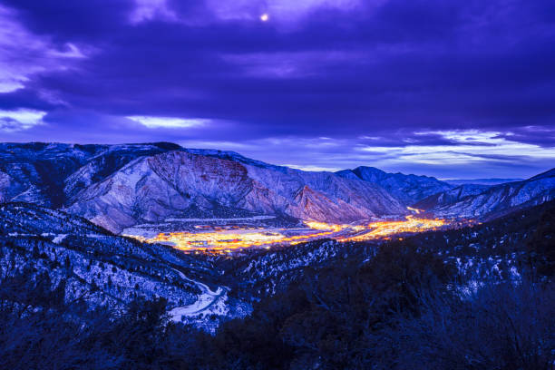 Glenwood Springs Scenic Blue Hour View - High angle view of town with Colorado River flowing along Interstate 70 corridor in western Colorado. Night view with lights and cityscape during dusk light. Light trails from vehicles driving at night.