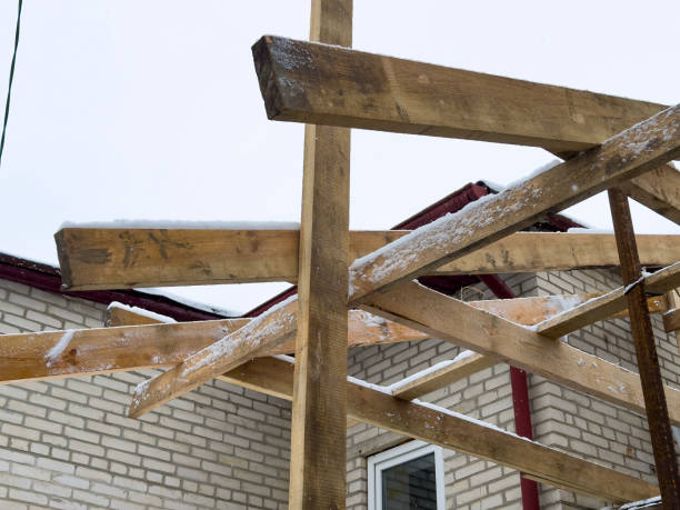 istock Workers are building a wooden framework for a structure in cold winter conditions near a brick house 2197269345