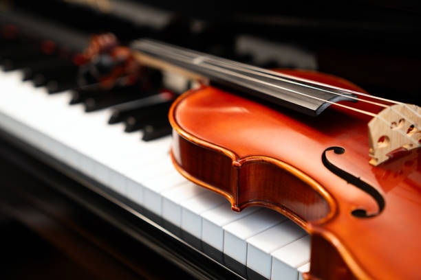 istock Violin on top of piano keyboard background 2197274754