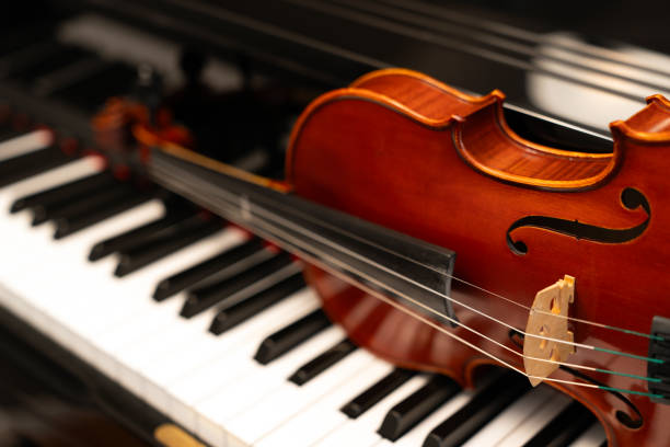 istock Violin on top of piano keyboard background 2197274782