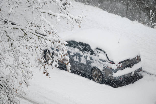 istock Snow-covered car parked on snowy street 2197275688