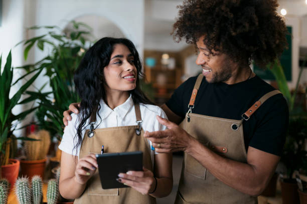 istock Florists discussing inventory management using digital tablet in plant shop 2197276416