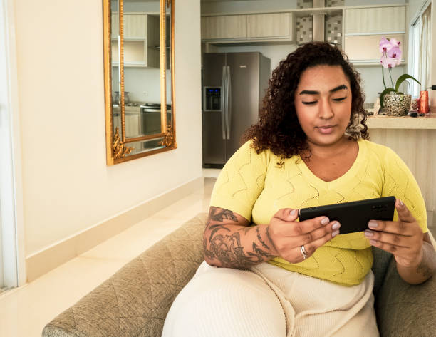 istock Young woman whatching TV on a smart phone 2197278249