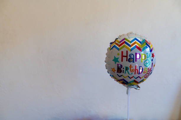 Happy birthday pink balloon in heart shape on turquoise background with blank background