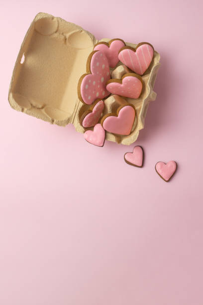 istock heart-shaped cookies with pink icing in an egg carton, vertical, creative baking concept for Valentine's Day 2197278885