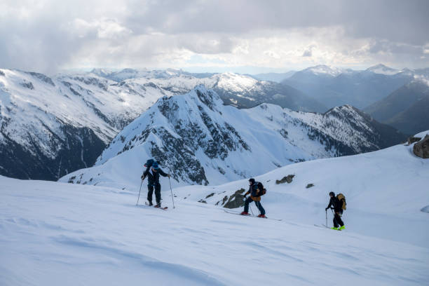 istock Backcountry skiers ascend snowcapped mountain 2197283323