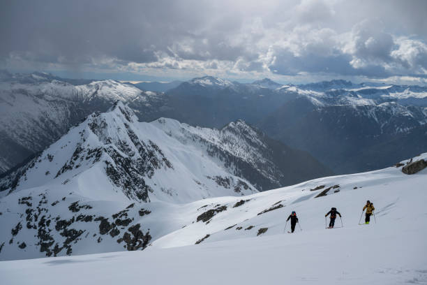 istock Backcountry skiers ascend snowcapped mountain 2197283392