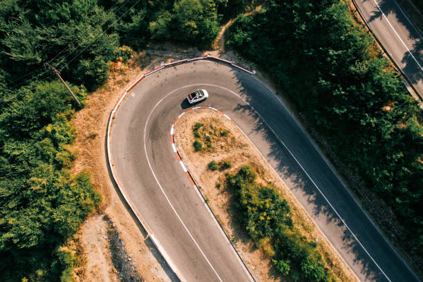 White convertible turns along a serpentine road in the mountains. Drone. High quality photo