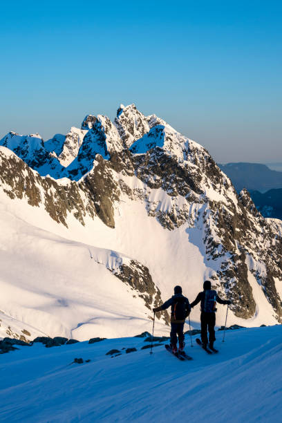 istock Backcountry skiers pause on mountain top 2197283694