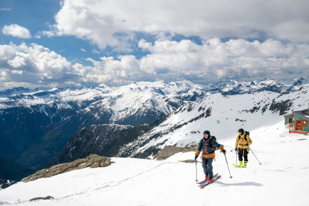 Backcountry skiers ascend snowcapped mountain