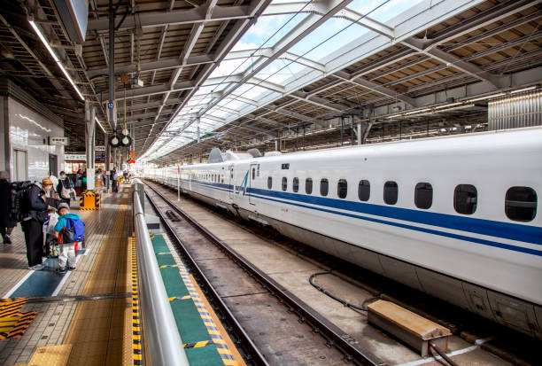 OSAKA, JAPAN - November 19, 2024.\nShinkansen N700 bullet train at Osaka Shin train station with people on the platform.