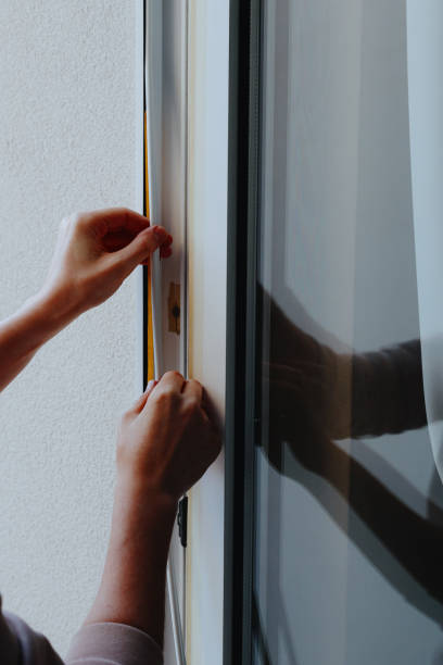 istock The hands of a young man insulate the window frame. 2197287068