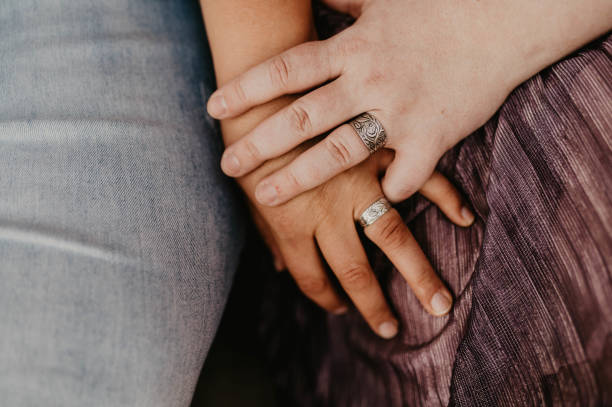 istock Close up of hands intertwined with rings 2197288224