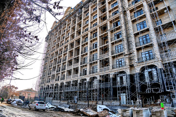 Facade of a multi-story building under construction with scaffolding and balconies.