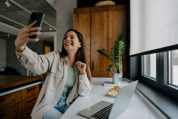 istock Young Woman Taking a Selfie While Having Breakfast in Her Modern Kitchen 2197296495