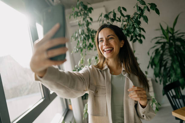 istock Young Woman Taking a Selfie with Plants in Background 2197296578
