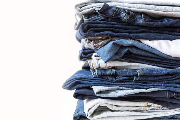 istock Stack of various shades of blue jeans on white background 2197297481
