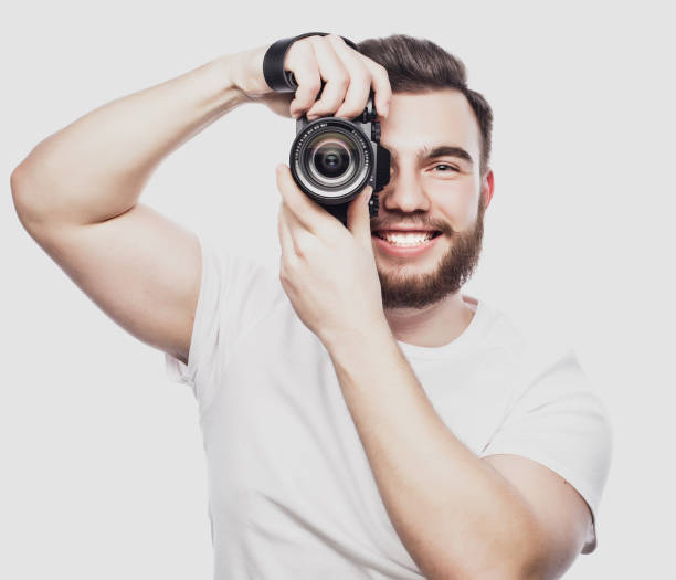 istock young bearded photographer taking pictures with digital camera. 2197298280