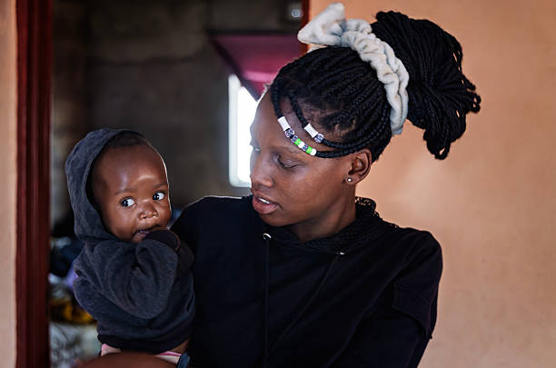 istock Young African mother holding baby, loving and caring expression 2197301853