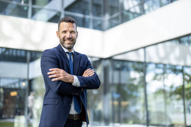 istock Smiling Businessman with Crossed Arms in Business Setting 2197308486