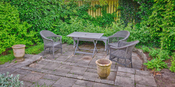 istock Beautiful private backyard garden with chairs and table surrounded by greenery 2197309021