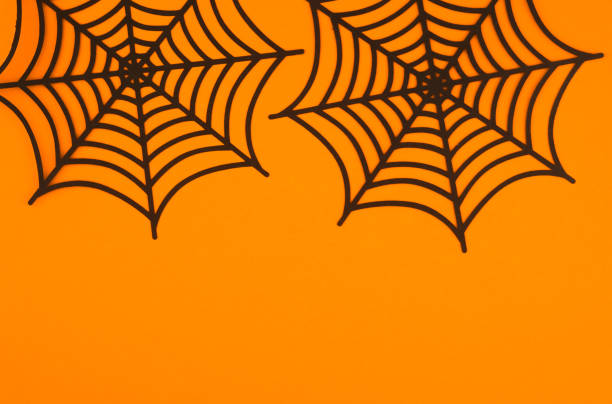 istock Black spider webs against a bright orange background for festive Halloween decor 2197309926