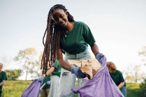 istock Young woman volunteer picking up trash in park 2197310565