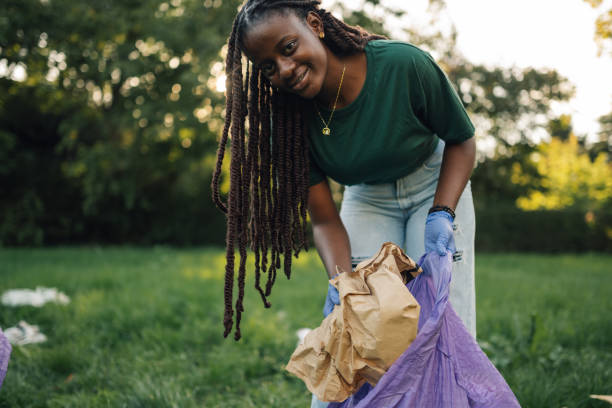 istock Young woman collecting trash in public park 2197310573