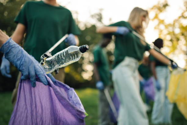 istock Volunteers collecting plastic bottle trash in park cleanup event 2197310575