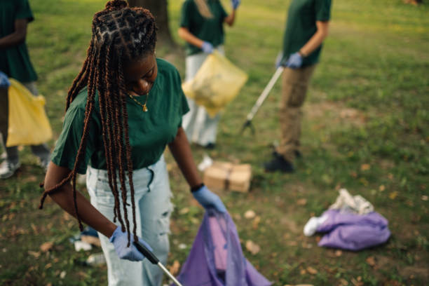 istock Volunteer picking up trash with grabber tool in park 2197310626