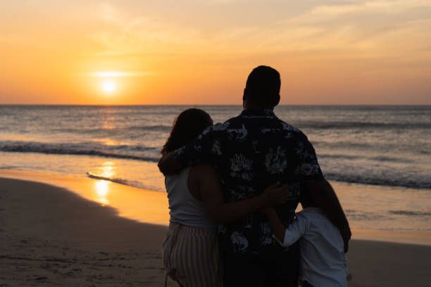 istock Family enjoying a beautiful sunset at the beach 2197318183