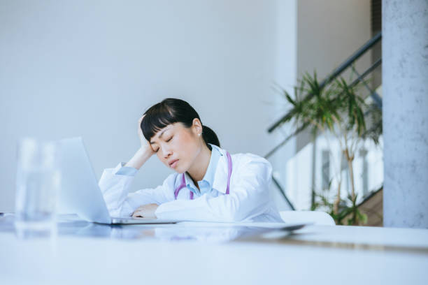 istock Tired nurse with a headache at the workstation 2197318892