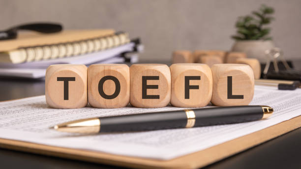 istock wooden blocks spelling TOEFL on a desk with documents, a pen, and study materials 2197320077