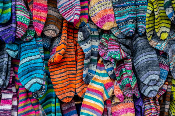 Close-Up Of Multi Colored Socks On Clothespins Hanging Against White Background