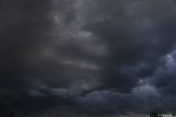 Dramatic dark storm rain clouds black sky background. Dark thunderstorm clouds rainny atmosphere. Meteorology danger windstorm disasters climate. Dark cloudscape storm disaster gloomy gray cloud sky
